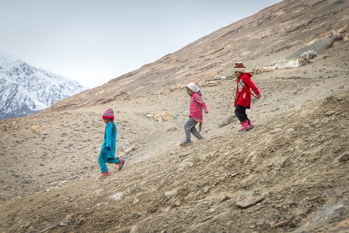 Three girls running down mountainside